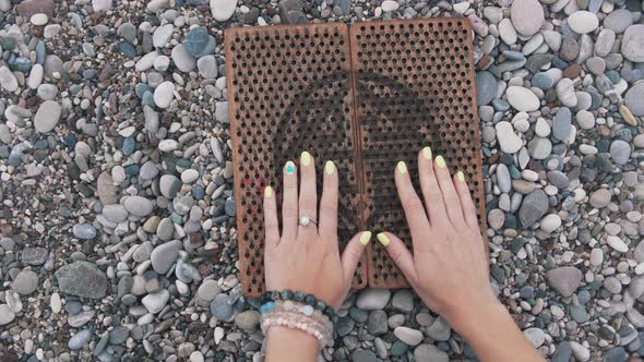 Female Hands with Painted Nails Touching the Sadhu Board on the Seashore