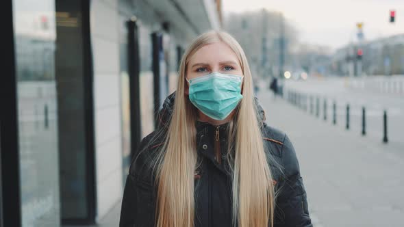 Young Blonde Woman Wearing a Protective Medical Mask on the Street