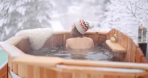 Woman Relaxing in Hot Bath at Snowy Mountains