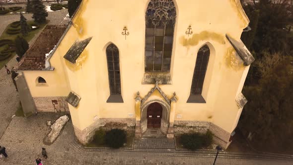 An upward pedestal drone shot, capturing a glimpse of a vintage architechture in a closed locality i