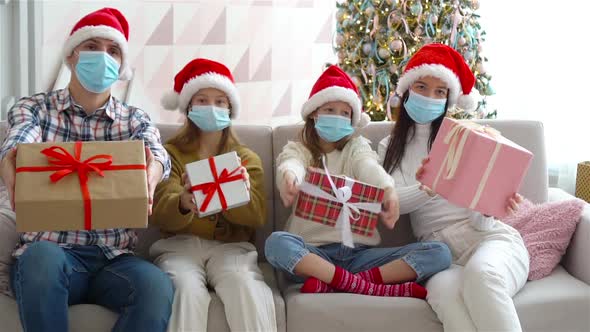 Happy Young Family with Kids Holding Christmas Presents