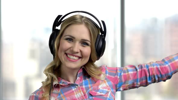 Young Cheerful Woman with Headphones Is Dancing.