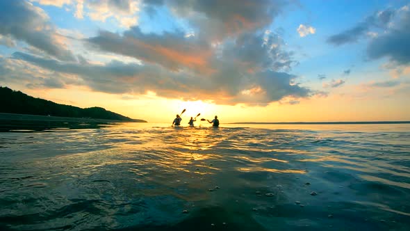 Group of Paddlers Are Kayaking Into the Sunset