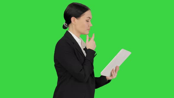 Businesswoman Using a Tablet Pad While Walking on a Green Screen Chroma Key