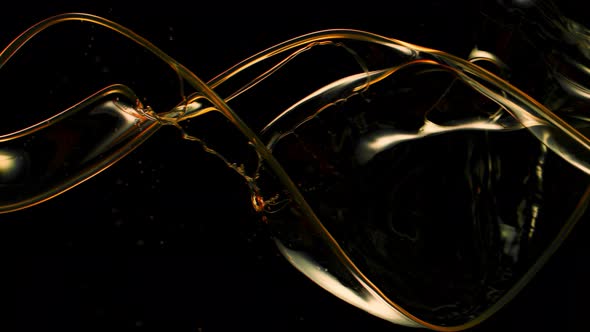 Super Slow Motion Shot of Swirling and Splashing Golden Oil Isolated on Black Background at 1000Fps