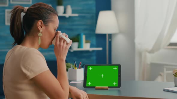 Caucasian Female Looking at Tablet Computer with Mock Up Green Screen