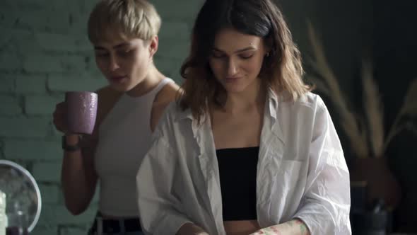 Young Beautiful Lesbian Women Are Cooking Dinner and Kissing at Table in Modern Kitchen Spbd.