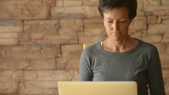 Mature Beautiful Woman Thinking While Using Laptop