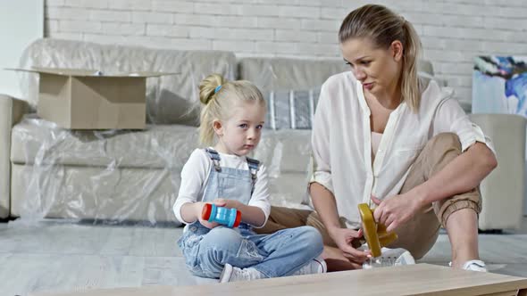 Shy Girl Playing with Toy in New Apartment