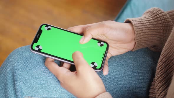 Woman Holding Mobile Phone with Green Screen Chroma Key and Marks Standing in Shopping Center Ready