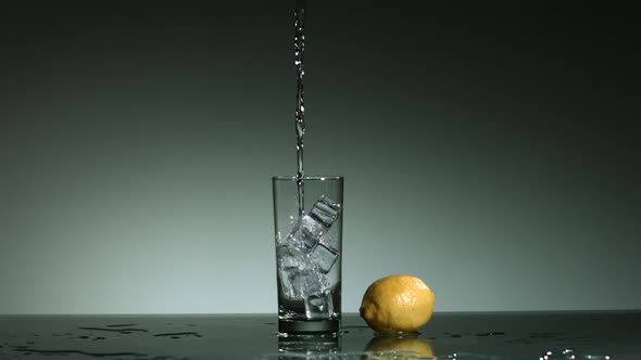 Carbonated liquid pouring into glass filled with ice