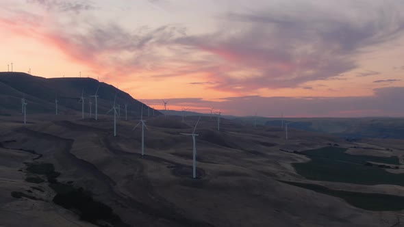 Aerial Landscape View of Wind Turbines on a Windy Hill during a colorful sunrise. Taken in Washingto