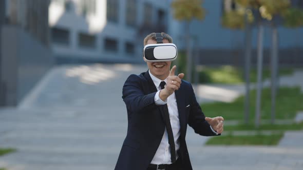 Happy Businessman Playing a Game on Imaginary Screen Using Augmented Reality Goggles