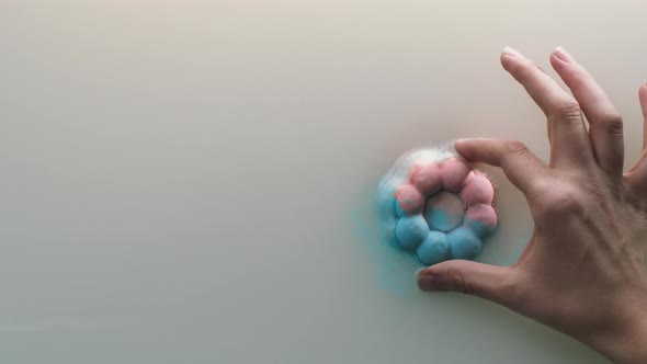 Hand Putting Bath Bomb Into Water Closeup