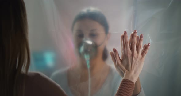 Young Woman Visiting Sick Aged Mother in Hospital Talking Through Plastic Curtain