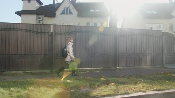 Blond Schoolage Girl Walks on the Road Home