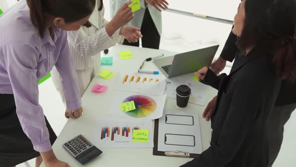 Business People Proficiently Discuss Work Project on Meeting Table