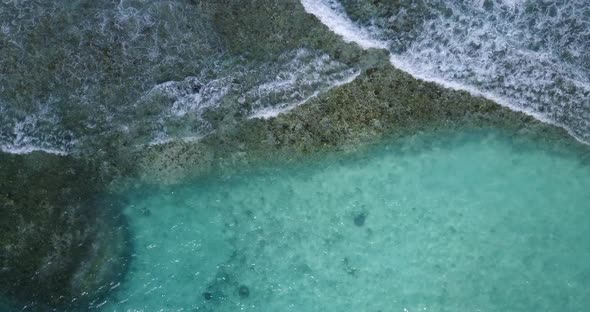 Daytime fly over island view of a white sandy paradise beach and aqua turquoise water background 