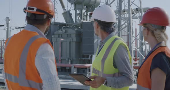 Engineer Showing Power Generator To Colleagues