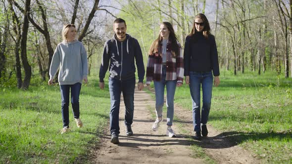 Four Friends are Walking in the Park in Nature