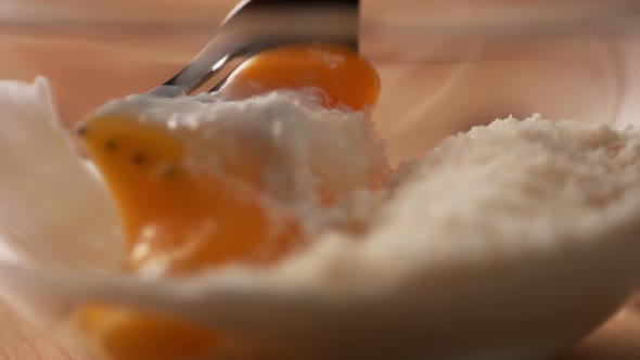 Camera follows mixing eggs with bread crumb in a bowl. Slow Motion.