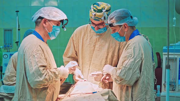 Team of Surgeon Operation on a Patient at Surgery Clinic