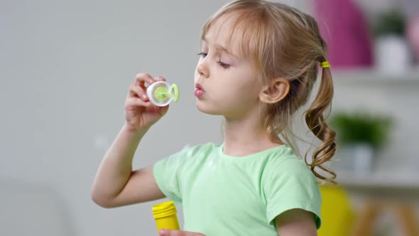 Cute Girl Blowing Soap Bubbles alt