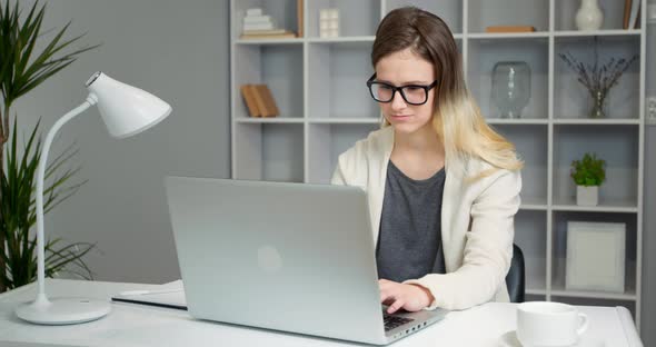 Girl student uses a laptop while sitting in the room.