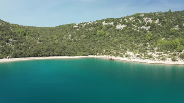 Wide aerial shot of a beautiful landscape with a ship wreck on the right side of the frame. Camera f