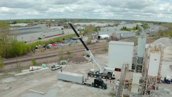 Crane Unloads the Carrier's Truck at the Factory