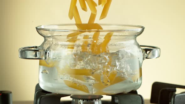 Super Slow Motion Shot of Fresh Penne Falling Into Boiling Salted Water at 1000 Fps.