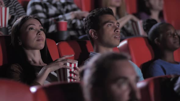 Mixed Race Couple Watching Scary Movie in Cinema