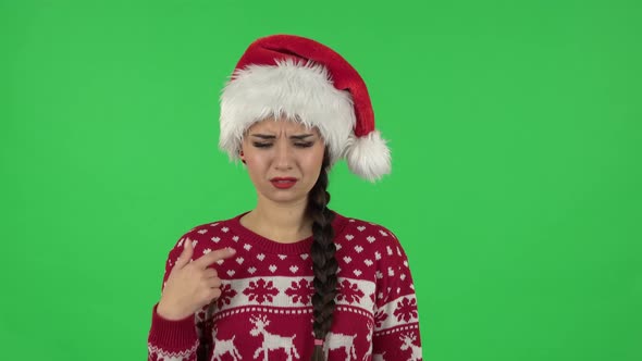 Portrait of Sweety Girl in Santa Claus Hat Is Outraging and Refusing, Gesticulating with Hands