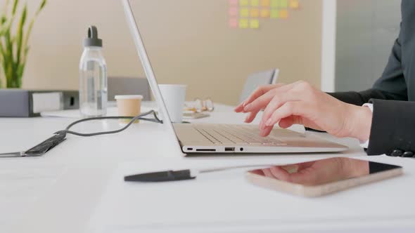 Hands of businesswoman typing on laptop