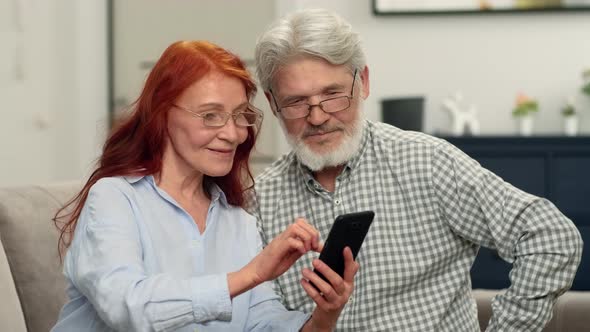 A Senior Couple in Their 60s Make an Online Purchase Using a Smartphone