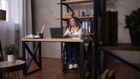 Woman in Wheelchair Stretching During Work at Home