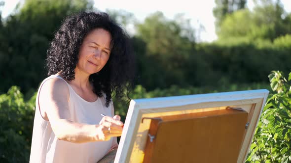 Female Artist Painting a Colorful Painting Outdoors