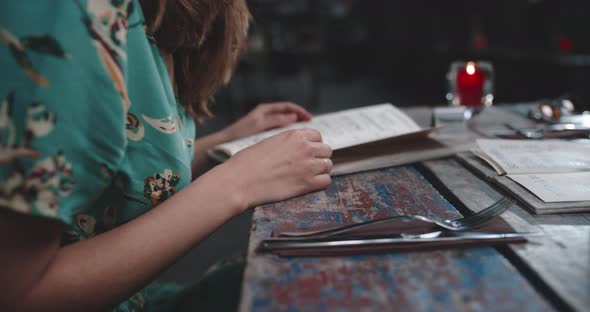 Young woman looks at the menucard