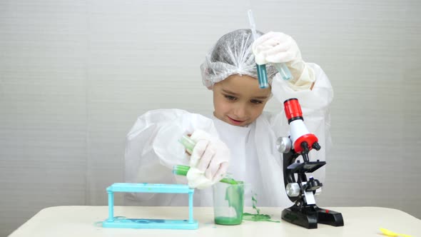 A Cute Boy in a Medical Suit Conducts Experiments