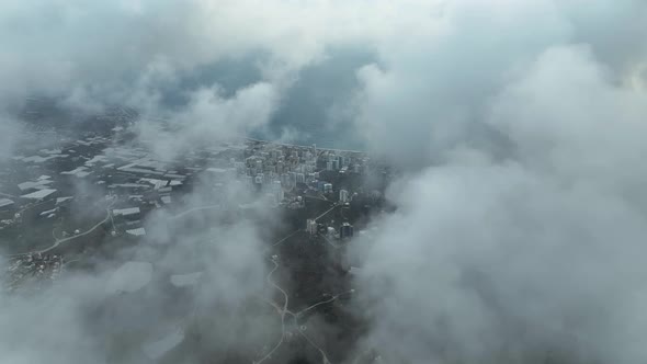 Over the city in the clouds aerial view 4 K