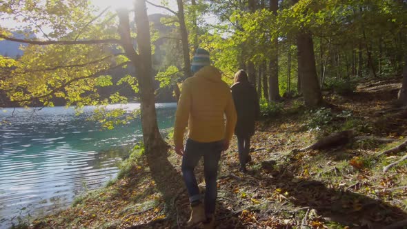 Couple walking along lake, Parco Naturale dei Laghi di Fusine, Italy