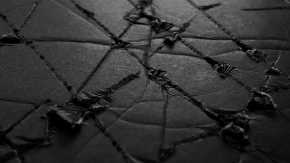 Black scratched torn worn paper. Abstract damaged surface. Macro
