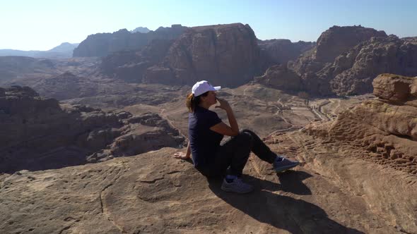 Beautiful Woman Sitting at Top Peak of the Mountains and Smoking a Cigarette, Outdoors Unusual Weird