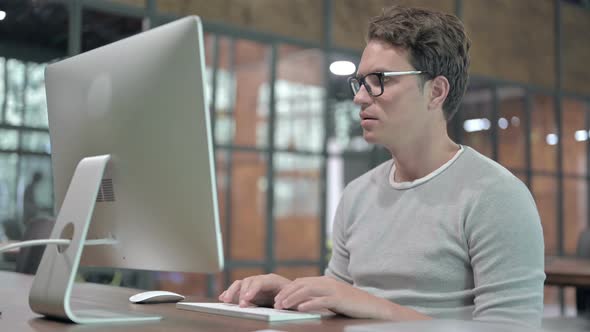 Ambitious Young Guy Working on Computer