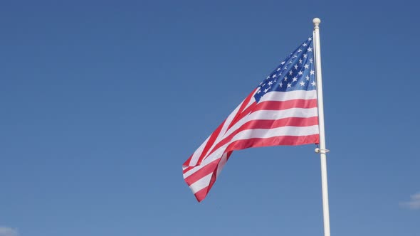 World famous American flag waving in front of blue sky 4K 2160p 30fps UHD footage - Recognaizable fl