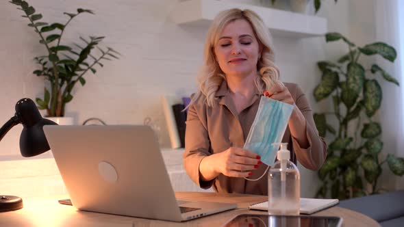 An Adult Woman Wears a Medical Mask When Working From Home