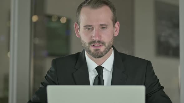 Close Up of Ambitious Businessman Doing Video Chat on Laptop at Night