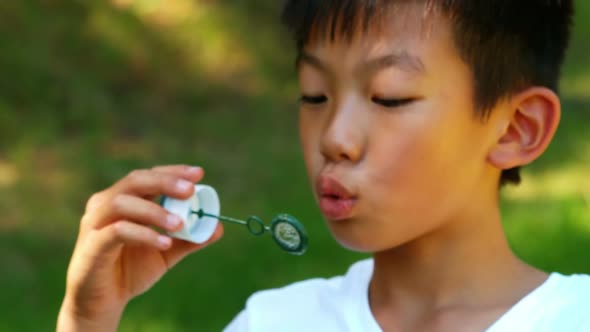 Boy blowing bubble with wand