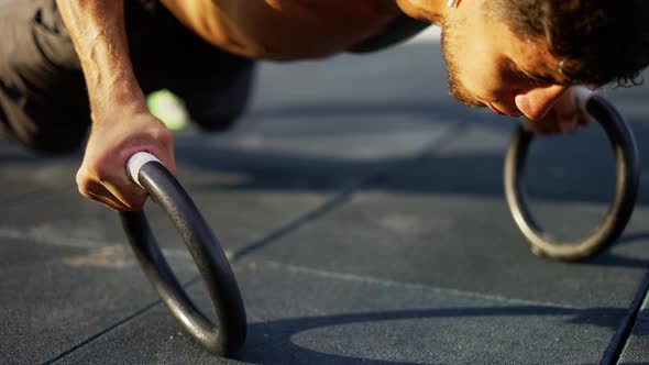 Strong Man is Doing Pushups By Rings