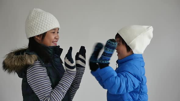 Cute Asian Child  In Winter Clothes Playing On Gray Background Slow Motion